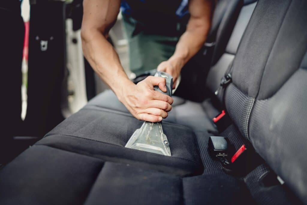 Professional interior car cleaning service in Birmingham, showcasing thorough vacuuming and detailed cleaning of seats, carpets, and dashboard.